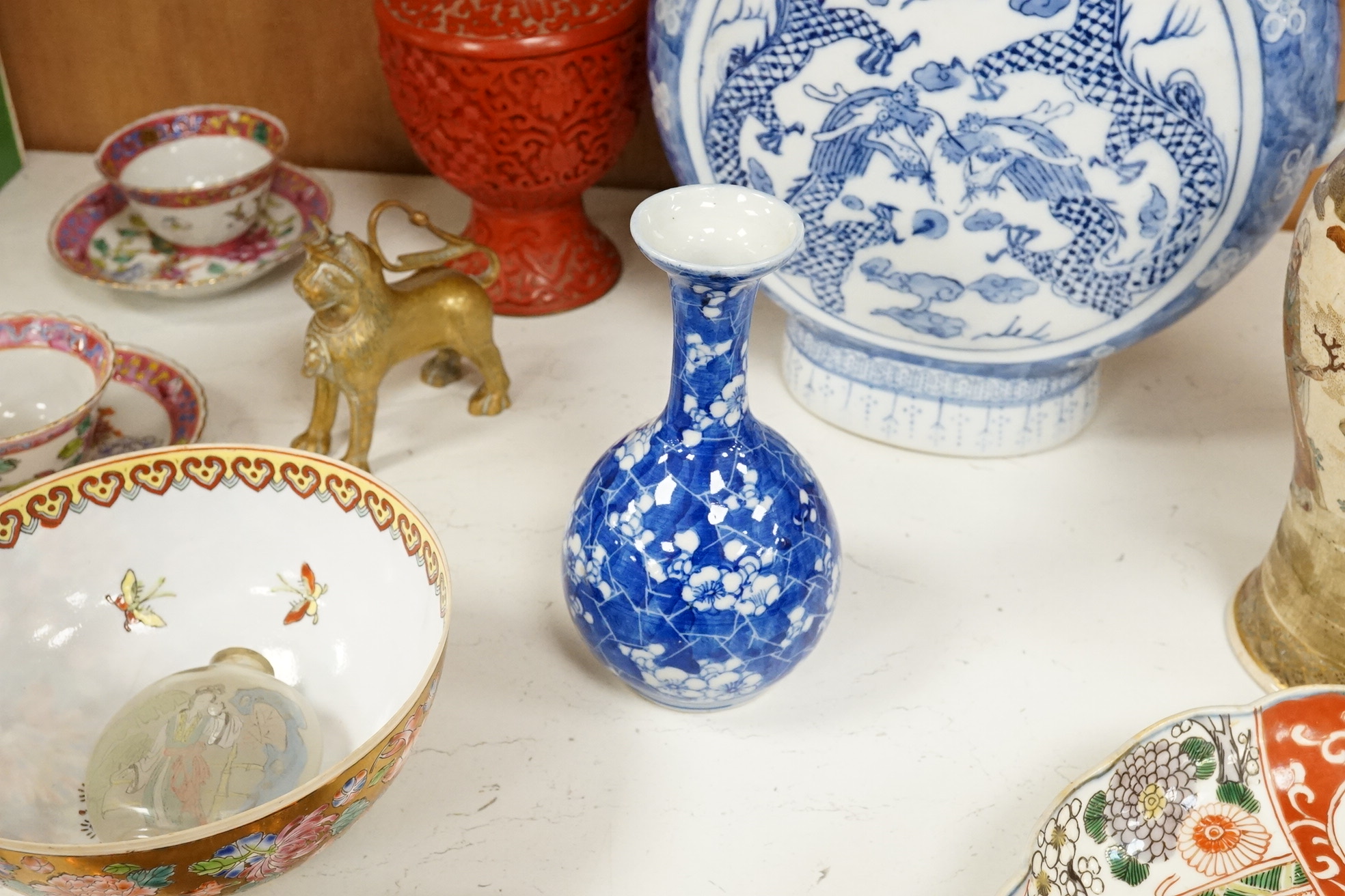 A group of mixed oriental porcelain and metalware to include a Japanese satsuma vase, cinnabar lacquer vase and blue and white teapot, largest 32cm high.